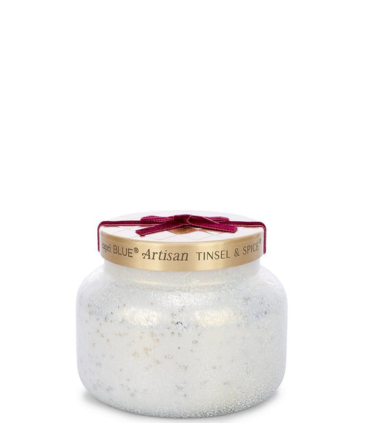 Capri Blue Tinsel & Spice Winter Bazaar Candle in a textured white jar with a gold lid and festive red bow.