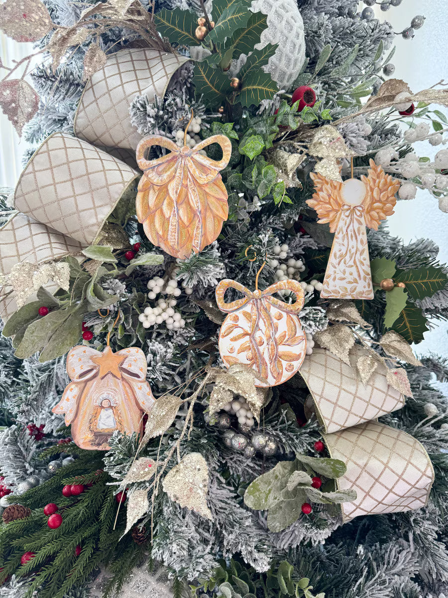 Gold Bow Manger & Baby Jesus Ornament, a bell-shaped nativity scene with a star & bow, on a festive flocked Christmas tree.