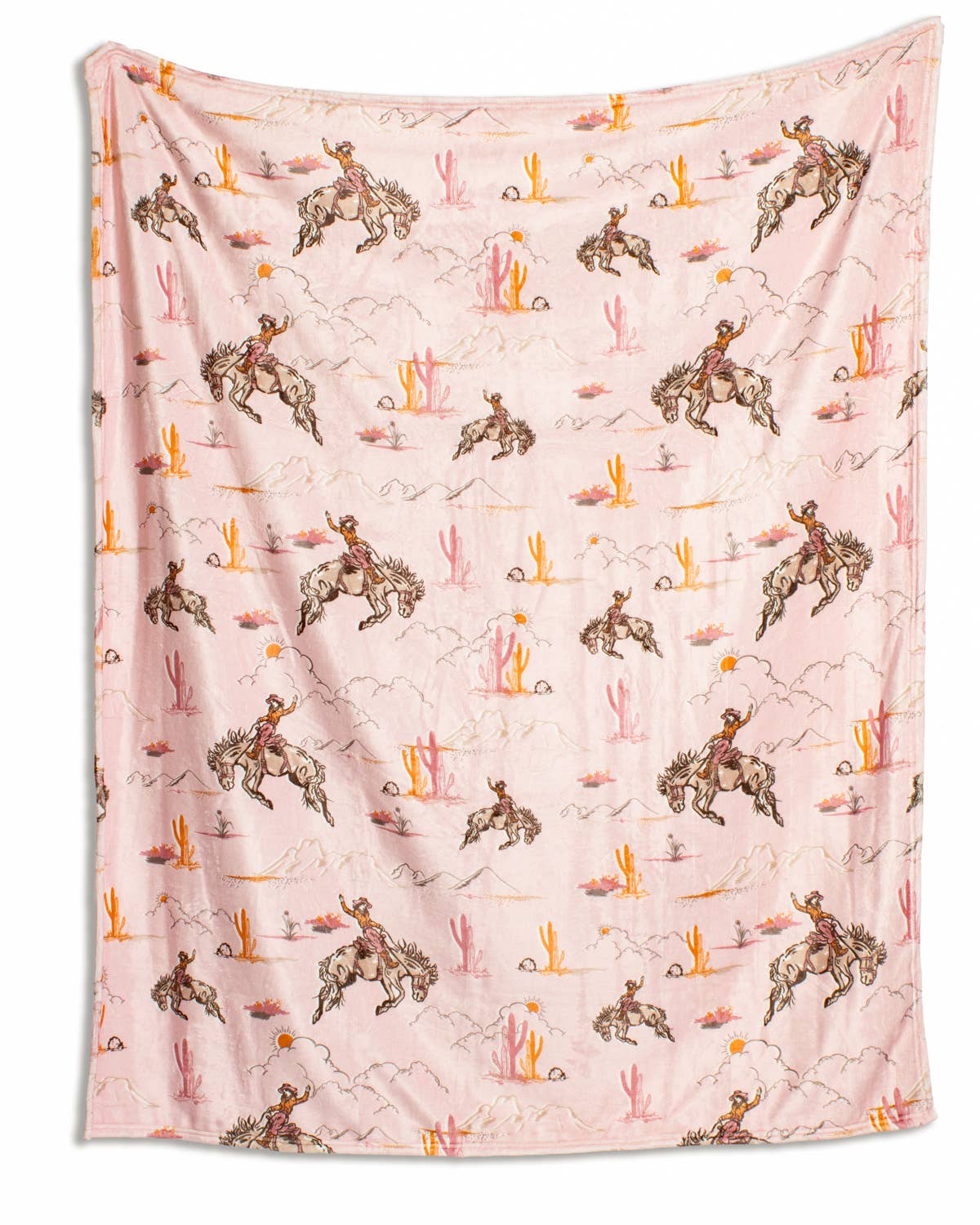 Pink Howdy Hunny Throw blanket with repeating pattern of cowboys on horses, cacti, mountains, and suns.
