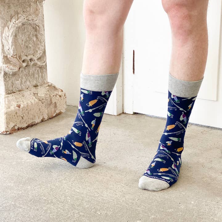 Men's Hook Line And Sinker Socks from The Royal Standard. Navy blue with fishing lure pattern and gray cuffs, worn by a person.